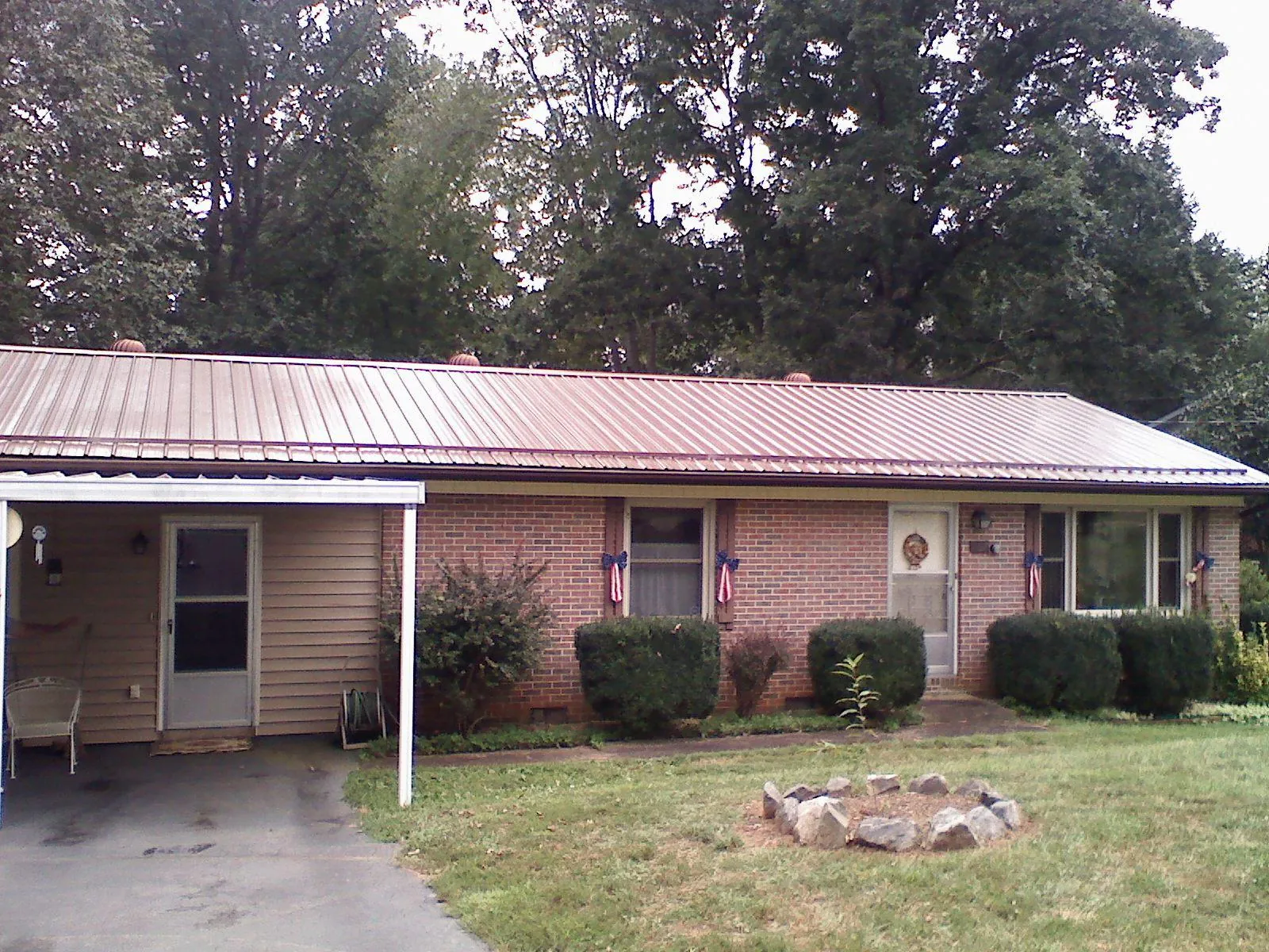 Bronze metal roof and carport on a brick ranch home — Roof Repair work by our crew in Missouri City