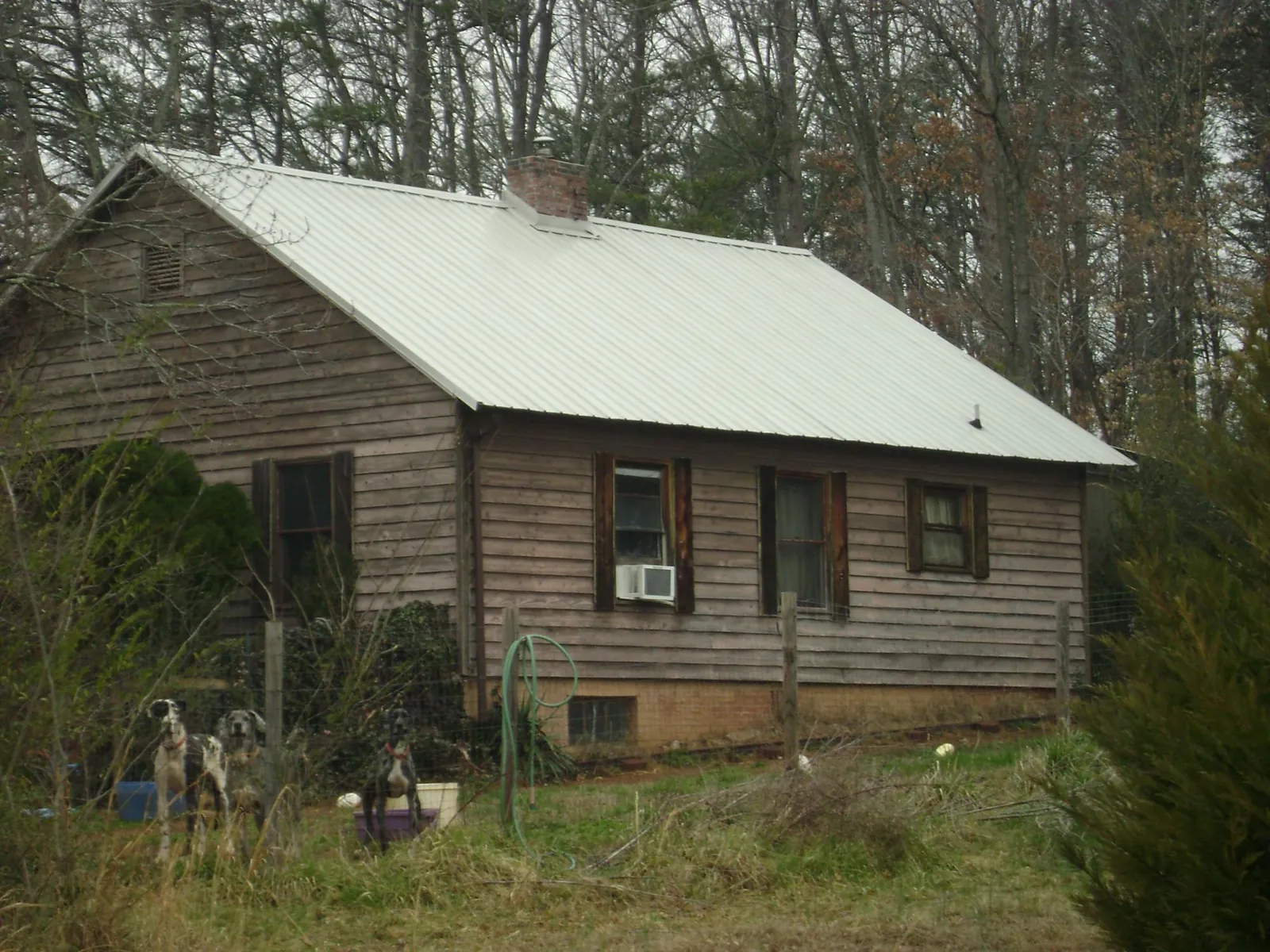 White metal roof on an old wood sided farmhouse, from a Asphalt Shingle Roof Repair job in Missouri City